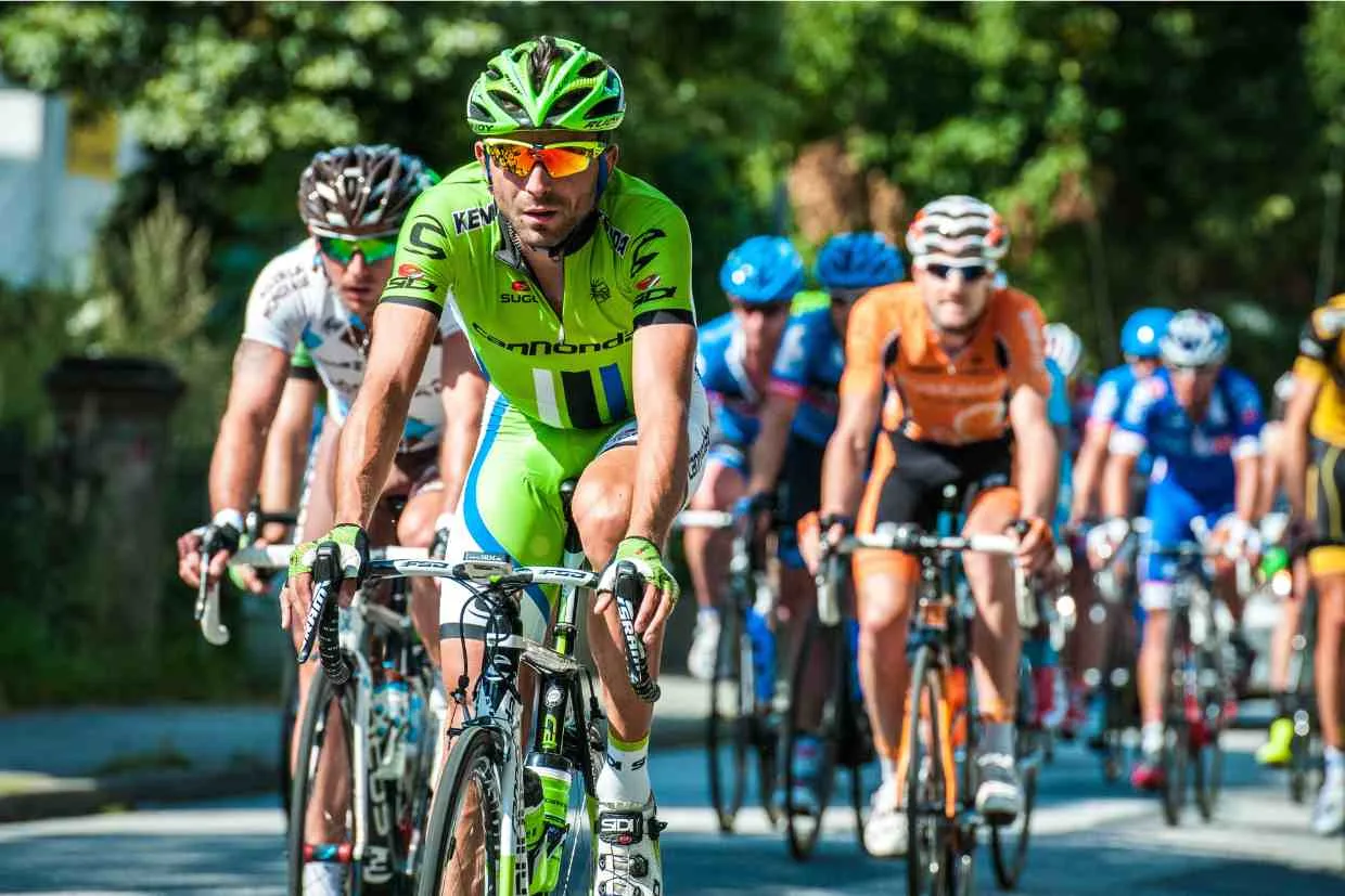 Pelotão de ciclistas durante prova de estrada, onde a fadiga muscular se torna um fator limitante no desempenho.