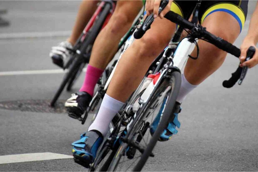 Ciclistas pedalando em alta velocidade em treino de estrada com planilhas de treino para ciclismo.