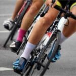 Ciclistas pedalando em alta velocidade em treino de estrada com planilhas de treino para ciclismo.