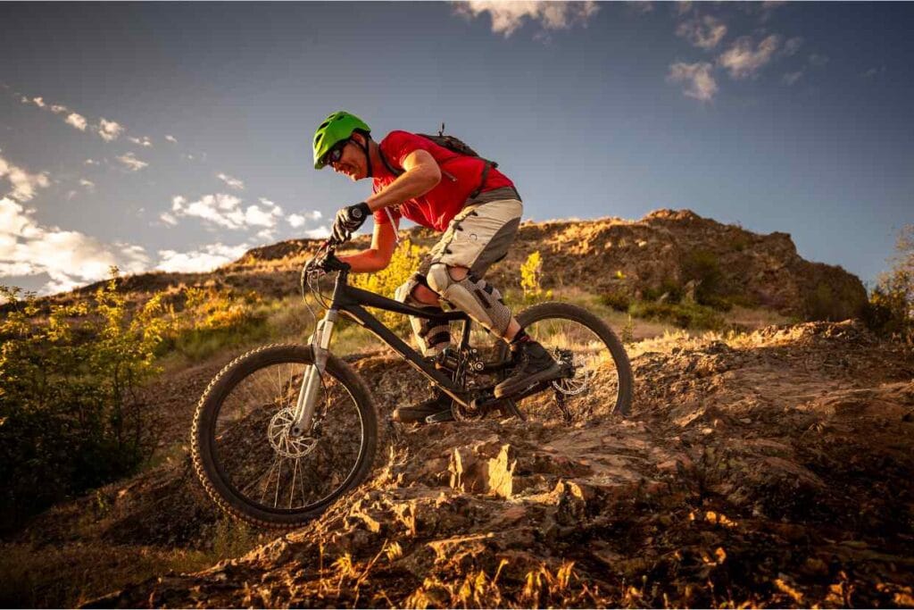 Ciclista descendo uma trilha de montanha com uma bike equipada para downhill após um upgrade bike realizado.