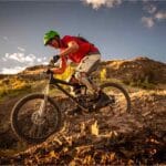 Ciclista descendo uma trilha de montanha com uma bike equipada para downhill após um upgrade bike realizado.