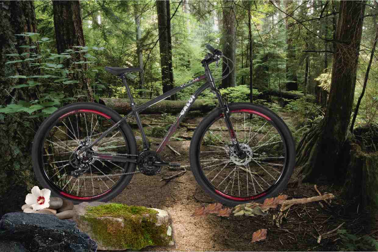 Bicicleta aro 29 Caloi Vulcan com grafismos coloridos sobre trilha de mata fechada