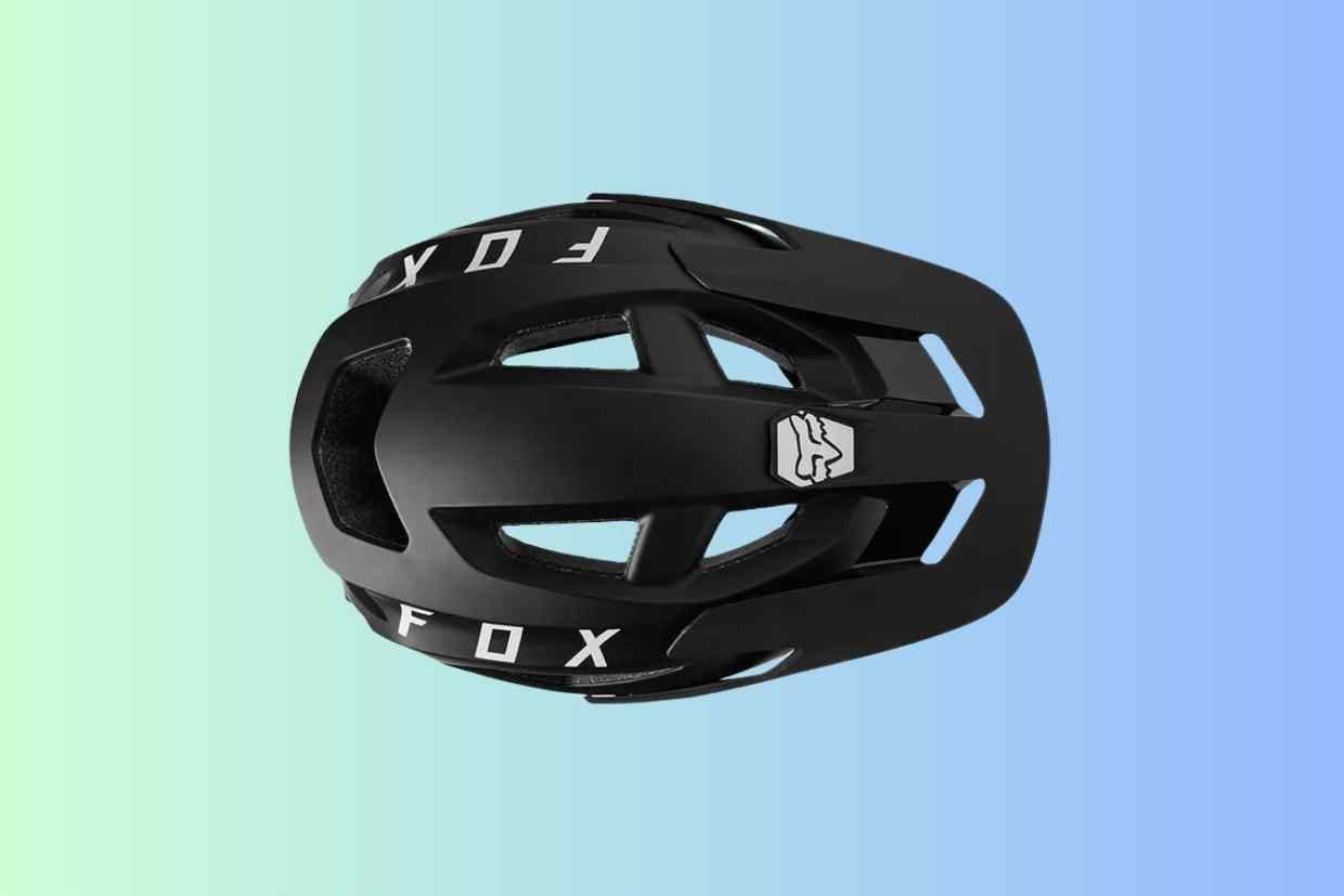 Imagem do capacete de ciclismo Fox Speedframe preto visto de cima sobre um fundo azul.