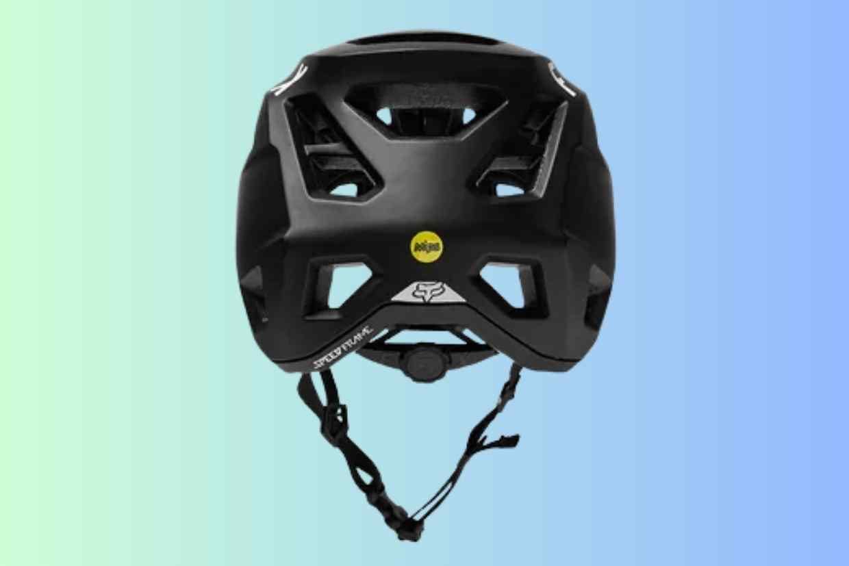 Imagem do capacete de ciclismo Fox Speedframe preto visto por trás colocado sobre um fundo azul.
