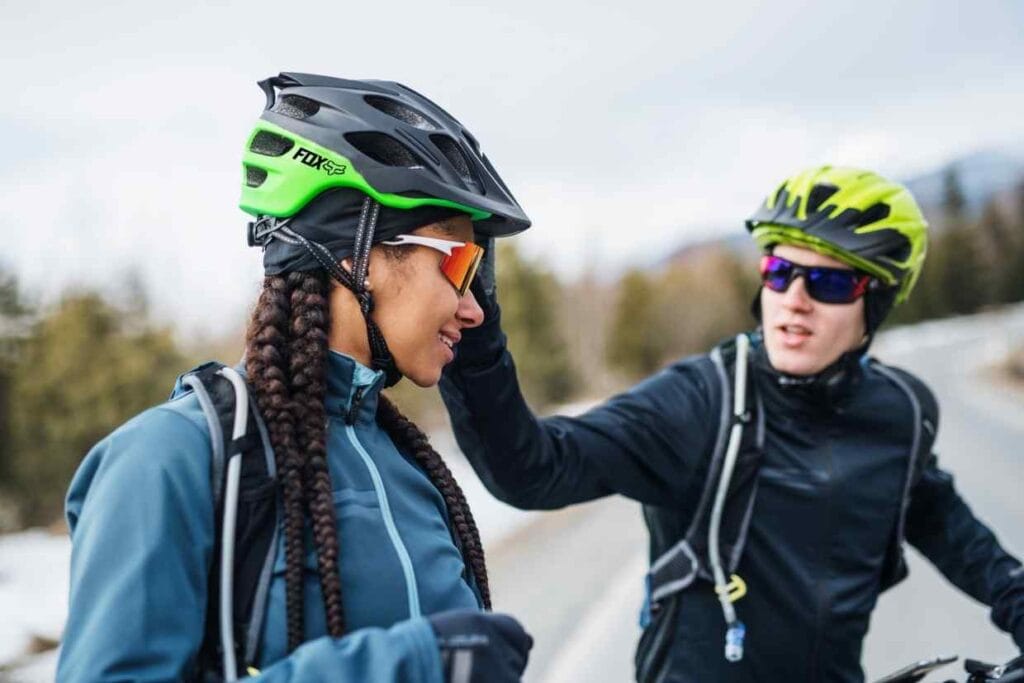 Imagem de um casal de ciclistas, usando o capacete de ciclismo Fox Speedframe, enquanto se preparam para o pedal.
