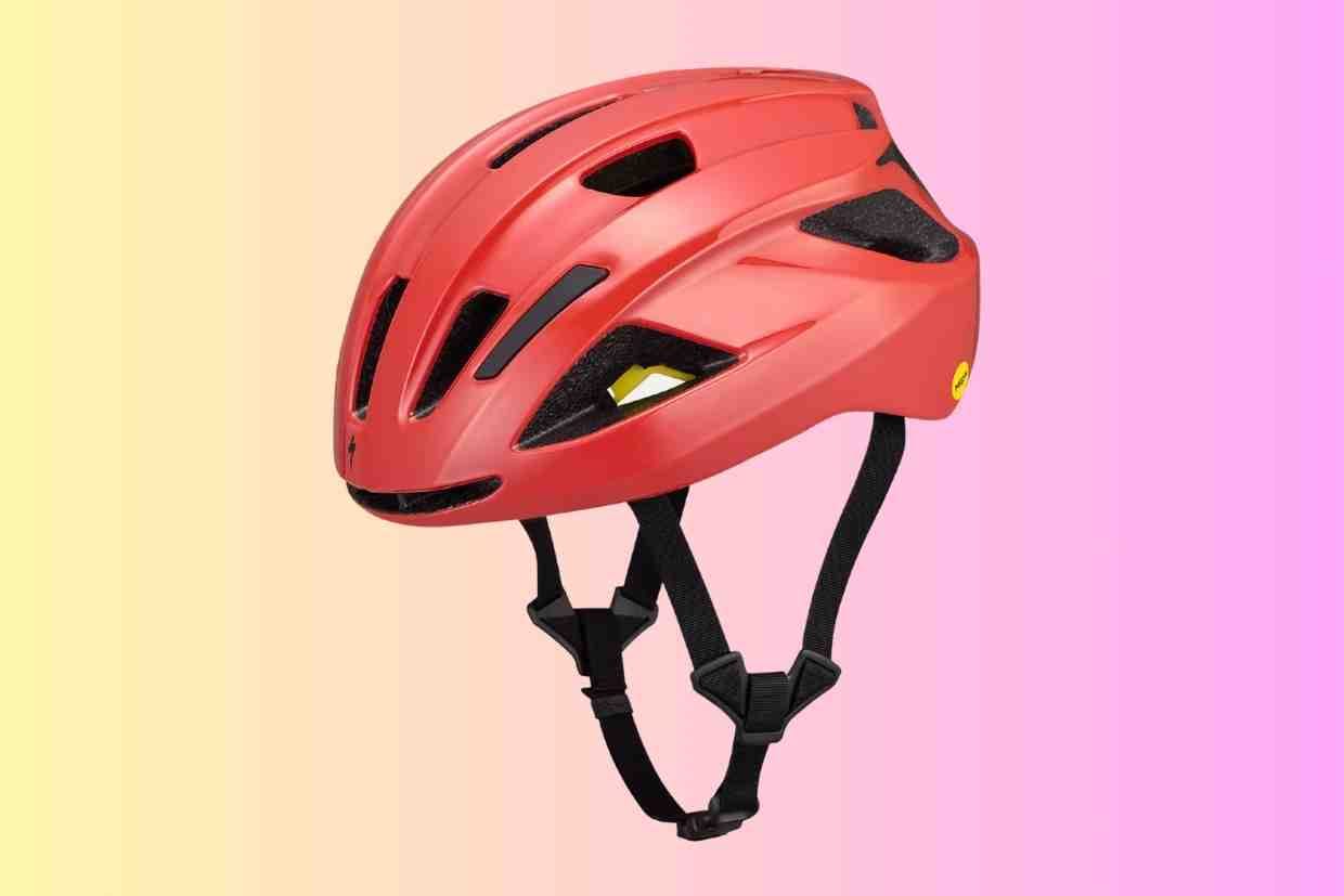 Imagem de um capacete bike feminino vermelho mostrando seus detalhes em perspectiva em um fundo gradiente rosa.