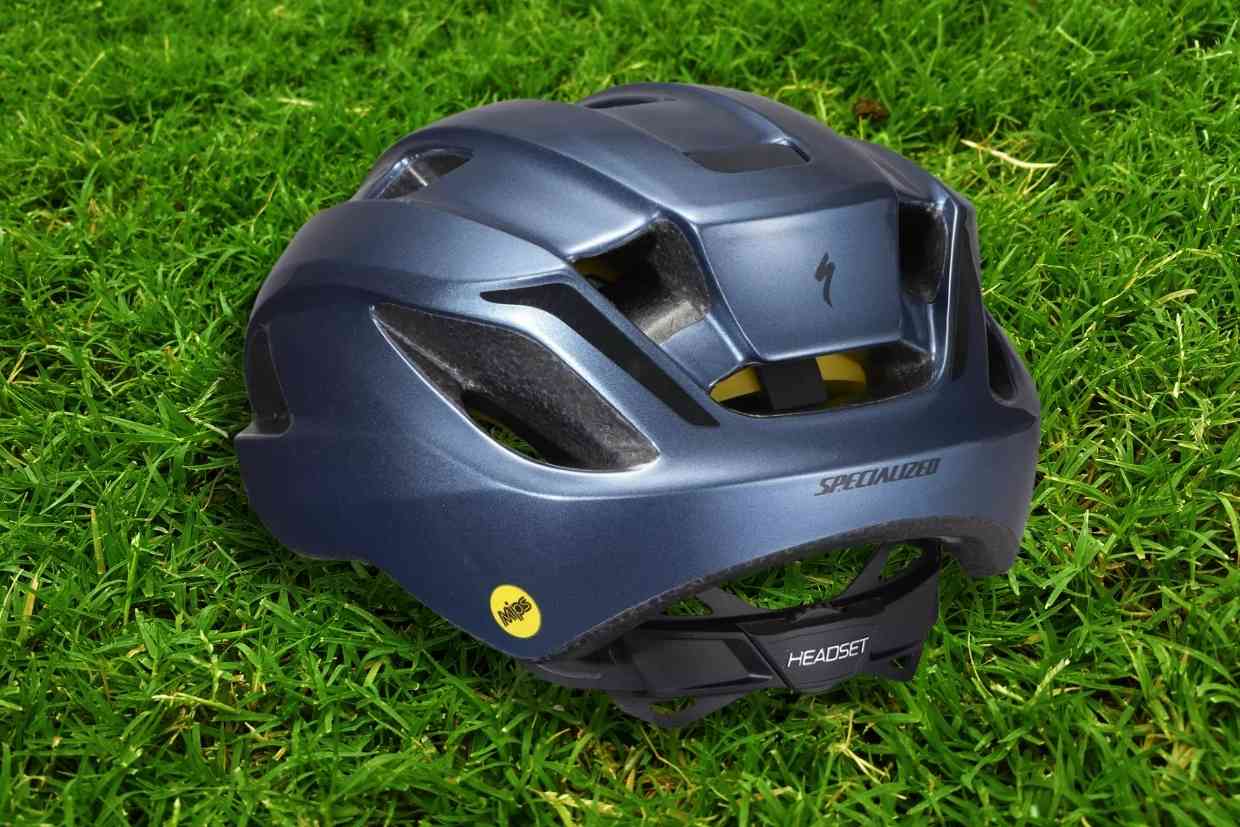 Imagem do capacete de ciclismo Specialized Align II azul-petróleo visto em perspectiva por trás, sobre um gramado verde.