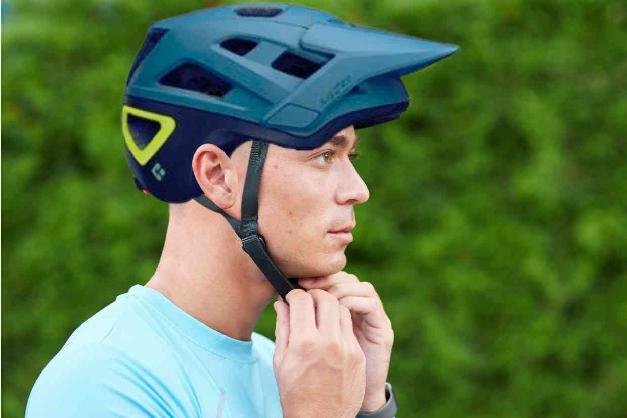 Ciclista ajusta seu capacete GIRO SWITCHBLADE MIPS na cabeça antes de iniciar seu pedal.