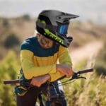 Ciclista de mountain bike descansa enquanto observa a paisagem usando seu capacete Giro Insurgent Spherical.