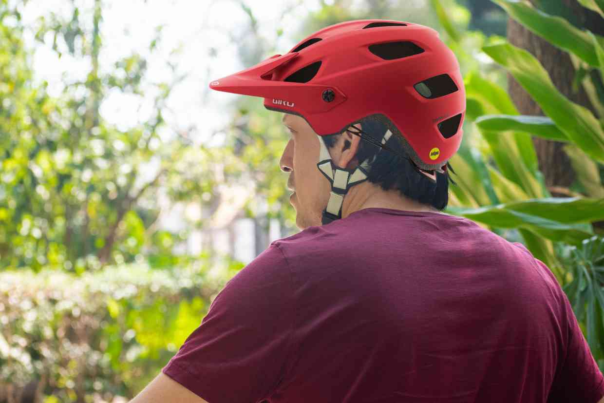 Ciclista numa pausa na trilha, observando a vegetação desfocada e usando uma capacete mtb Giro Chronicle MIPS.
