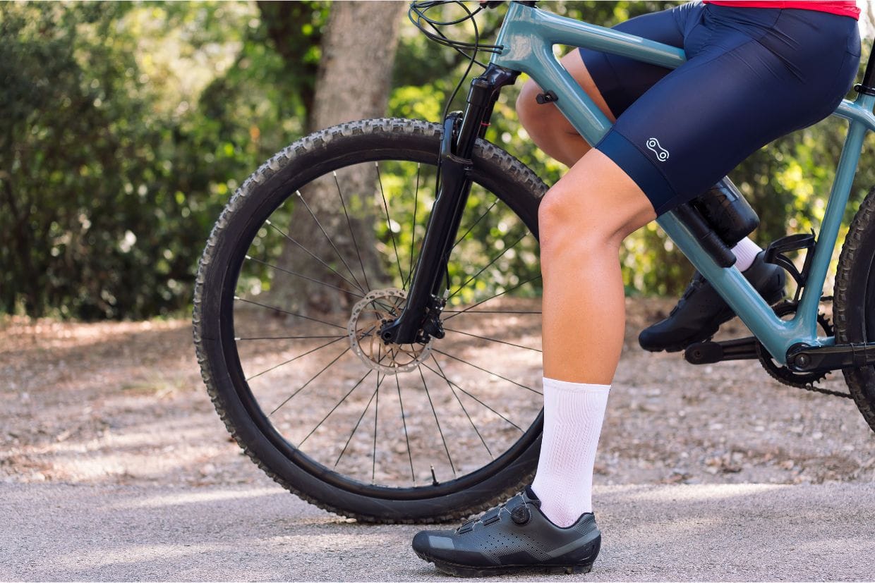 Ciclista sentado no quadro da sua bike usando uma bermuda Márcio May Light Bag preta.