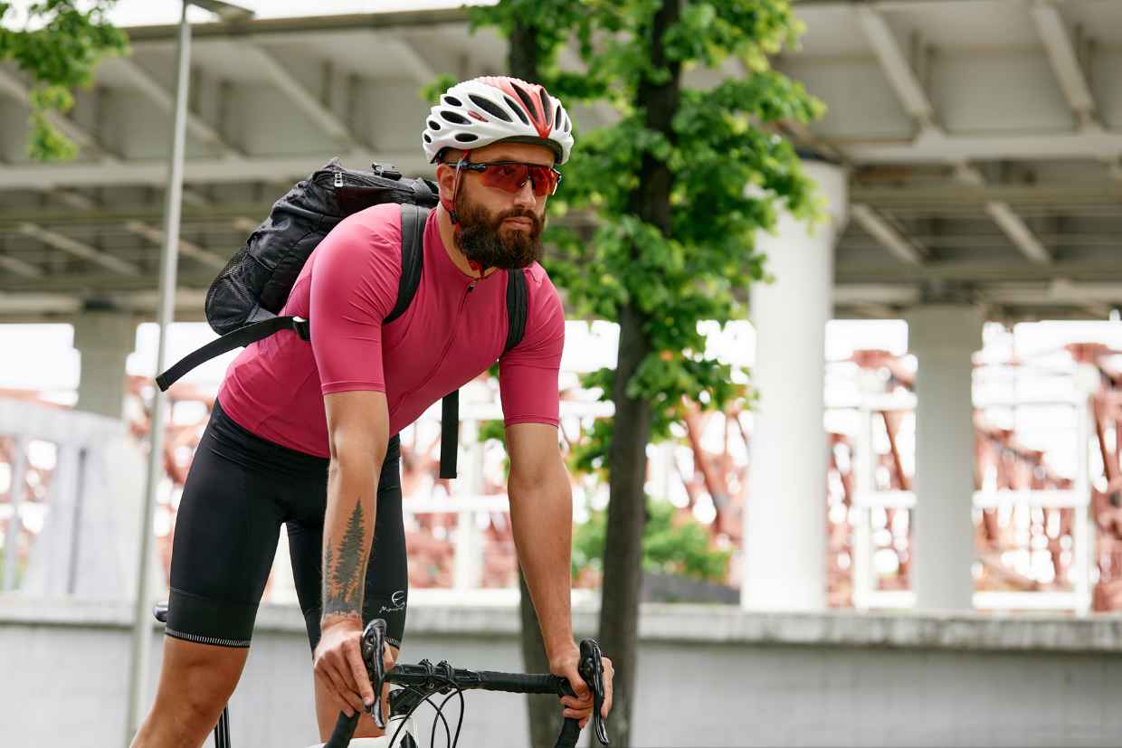 Ciclista de pé na sua bicicleta olhando para frente e usando bermuda de ciclismo Mauro Ribeiro Pocket